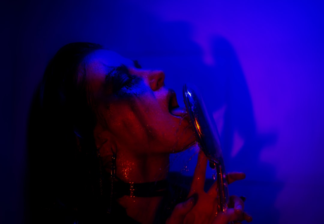 A woman singing into a microphone while holding a guitar